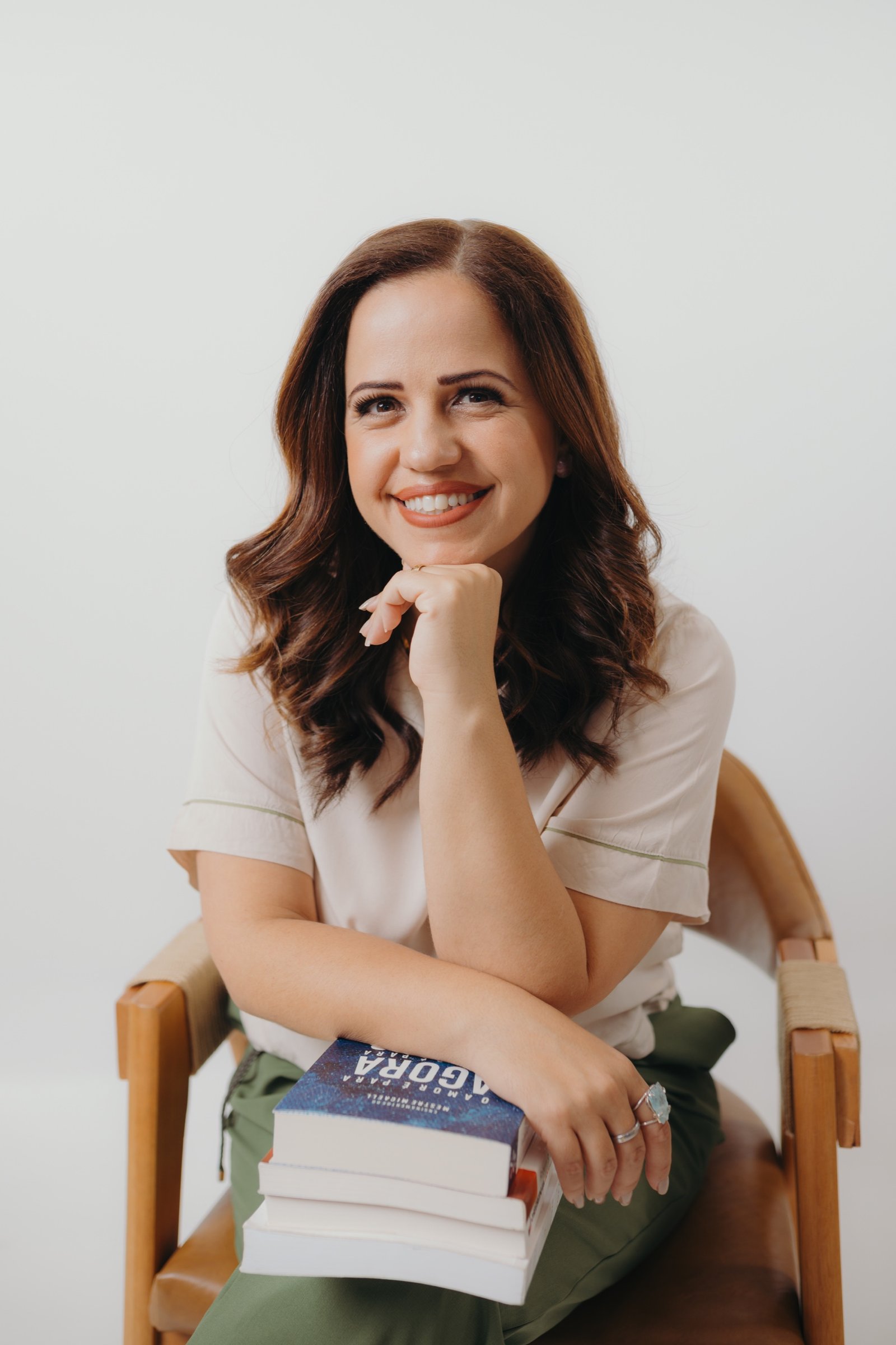 Sarah Carvalho sentada com livros sobre o colo